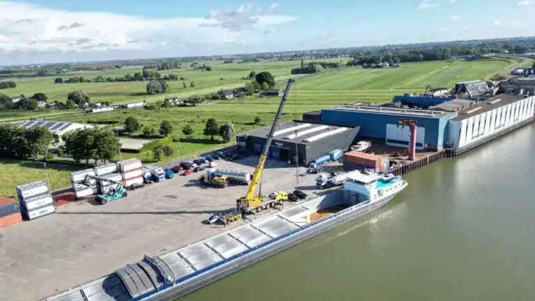 Dronefoto van een binnenvaartschip met prefab garages bij de loslocatie