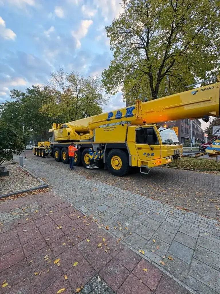 Mobiele kraan van P&K opgesteld op klinkers in een woonwijk
