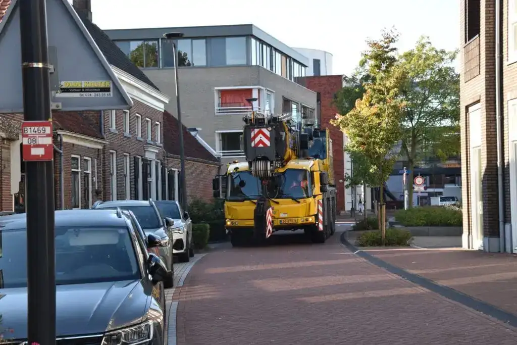 Autokraan van P&K aan het werk in een binnenstad