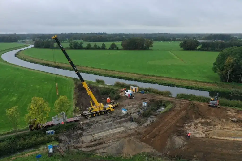 Mobiele kraan aan het werk langs een landweg in het buitengebied