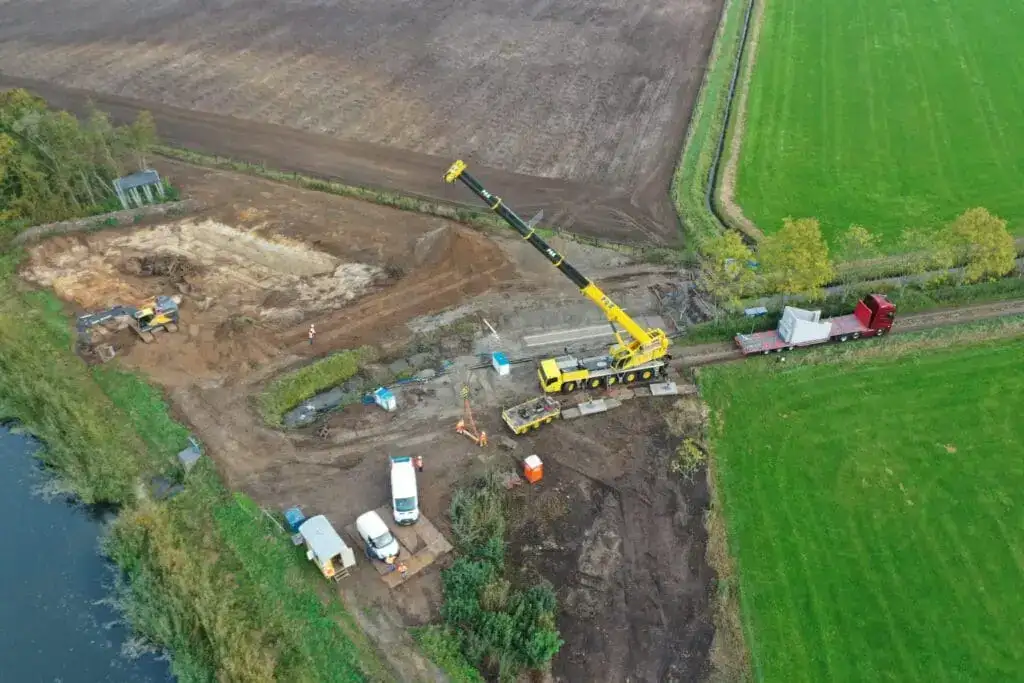 Luchtfoto van een bouwlocatie met een kraan van P&K in het weiland
