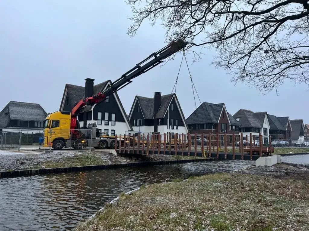 Autolaadkraan tilt materiaal over nieuwbouwwoningen heen