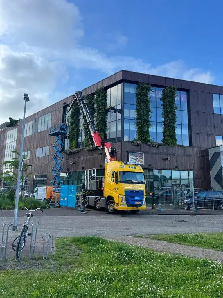 Autolaadkraan aan het werk bij een kantoorpand