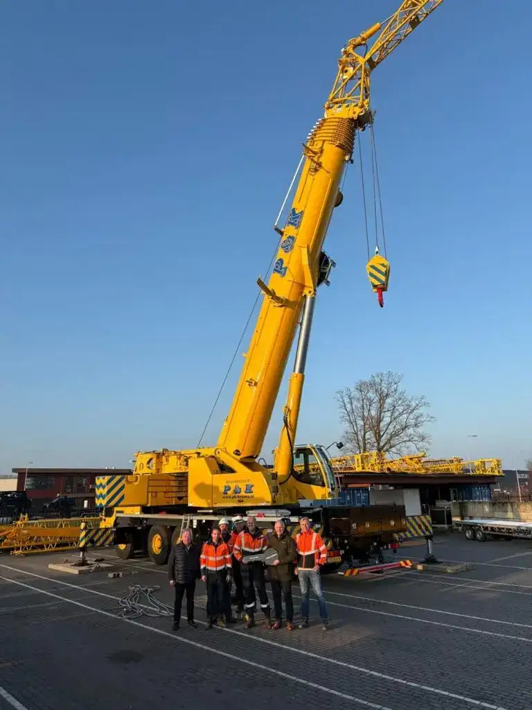 Giek en hijshaak van een mobiele kraan tegen een blauwe lucht