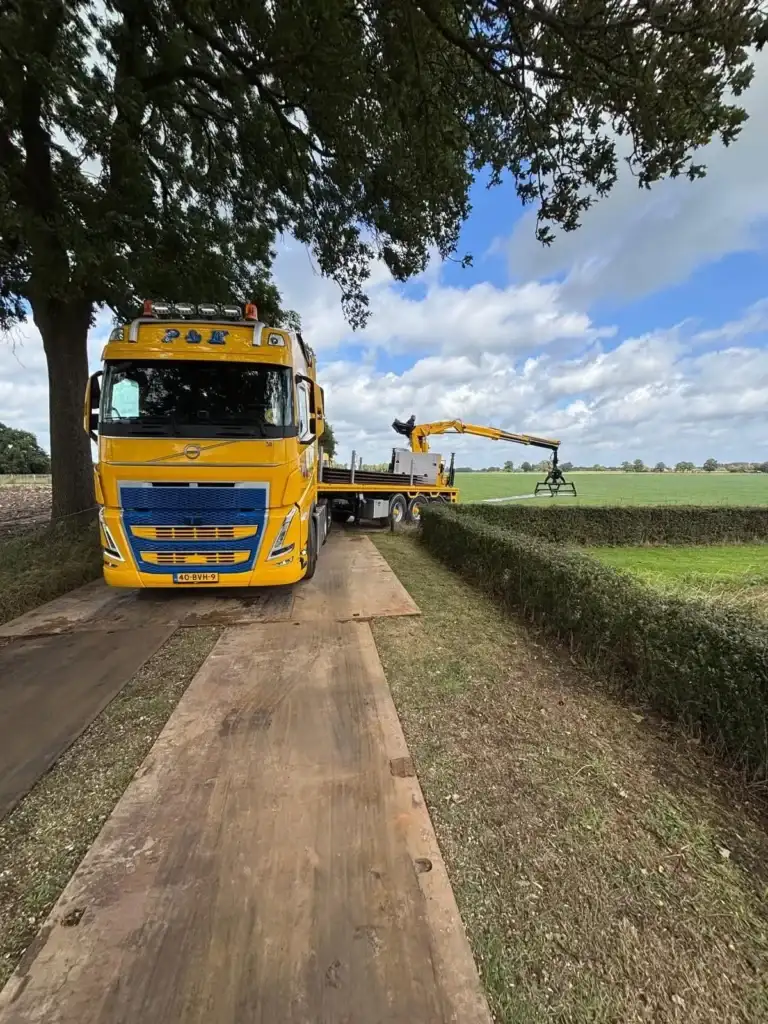 Vrachtwagen met autolaadkraan van P&K op houten draglineschotten