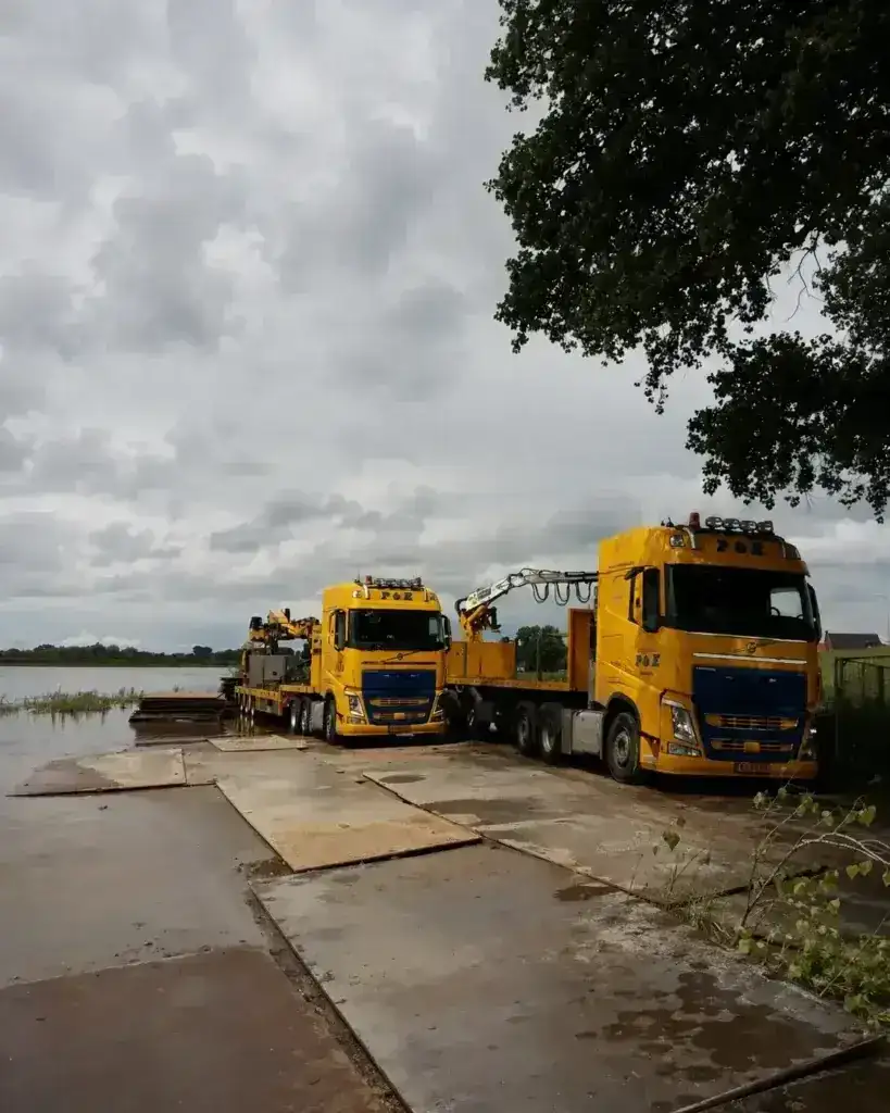 Rijplaten als tijdelijke rijbaan langs het water met vrachtwagens van P&K Kranen