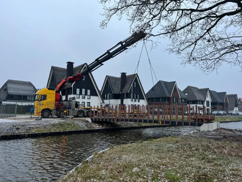 Autolaadkraan tilt materiaal over nieuwbouwwoningen heen