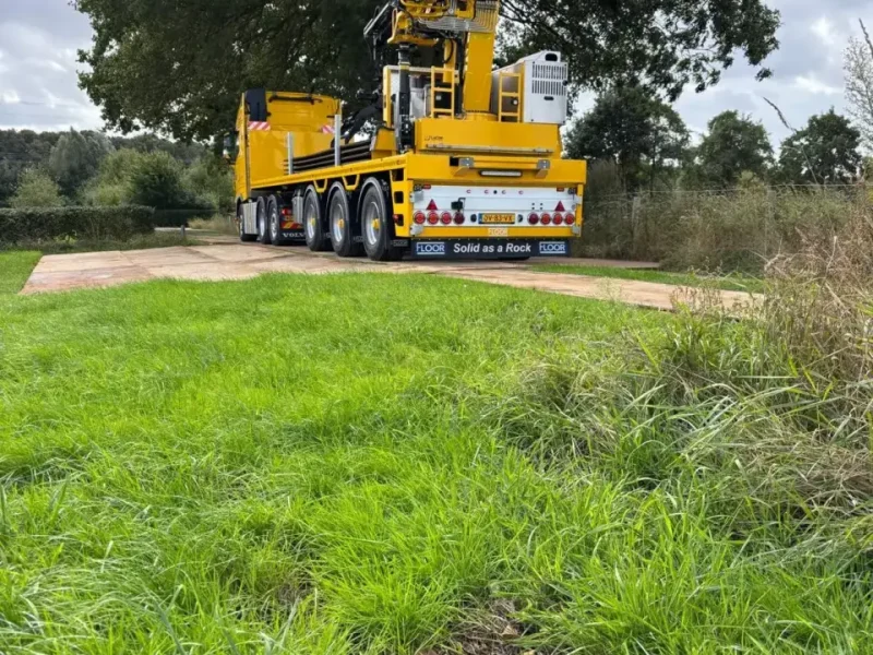Uitgestempelde autolaadkraan van P&K op een grasveld