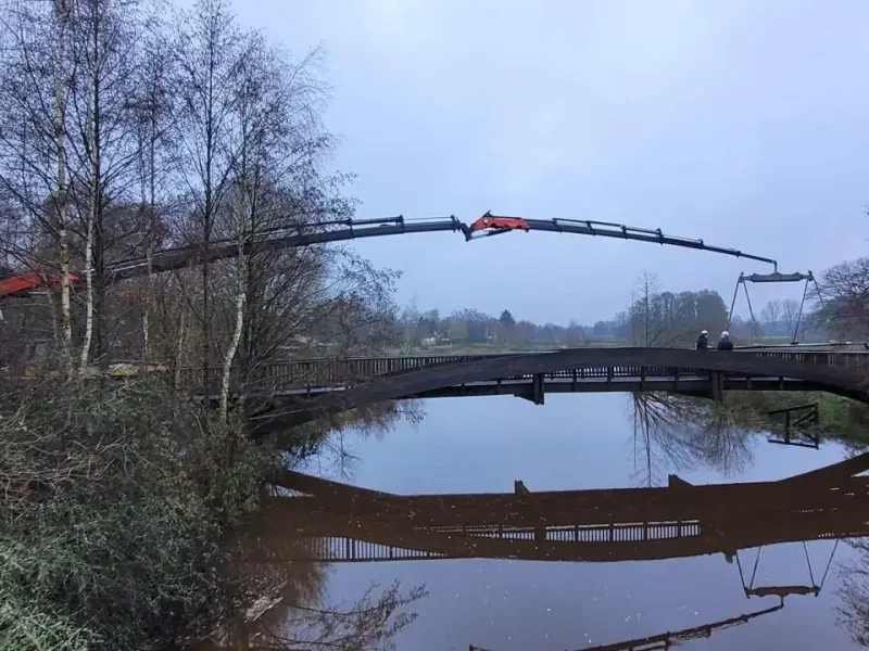 Brug over het water die met de autolaadkraan is geplaatst